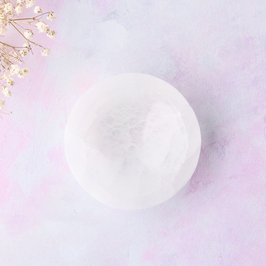 En selenitskål fotograferad uppifrån mot en rosa-lila bakgrund.